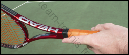 Raquette de tennis tenue avec l'index le long du manche
